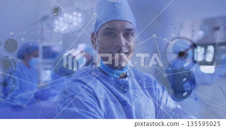 Standing and facing camera Hispanic surgeon in operating room with lights and network overlay Standing and facing camera Hispanic surgeon in operating room with lights and network overlay 135595025