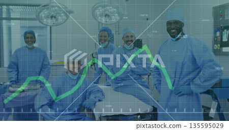 Surgical team wearing scrubs performing surgery in OR, with surgical lights and monitor graph Surgical team wearing scrubs performing surgery in OR, with surgical lights and monitor graph 135595029