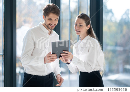 Young managers checking something online and looking excited Young managers checking something online and looking excited 135595656