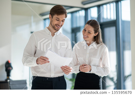 Caucasian man and woman working on the project together and looking involved Caucasian man and woman working on the project together and looking involved 135595670