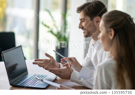 Colleagues having a video conference with the client and looking involved 135595730