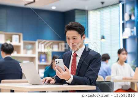 中年商人在辦公室使用智慧型手機 中年商人在辦公室使用智慧型手機 135595810