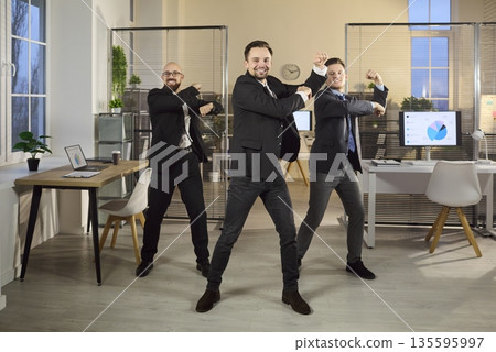 Businessmen perform office dance, celebrating achievement, teamwork and morale 135595997