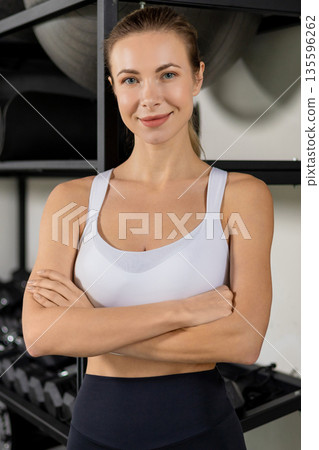 Pretty smiling blonde young woman looking confident and contented in the gym 135596262