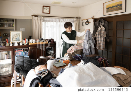 A woman organizing her clothes A woman organizing her clothes 135596543