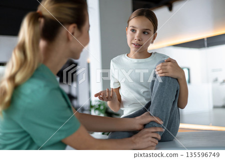 Therapist assisting patient during leg stretching and recovery practice Therapist assisting patient during leg stretching and recovery practice 135596749