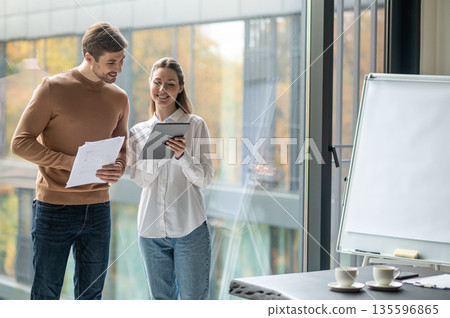 Two people working in the office and looking involved 135596865