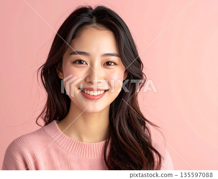 Smiling Japanese woman against a pink background | Gentle and friendly natural beauty portrait 135597088