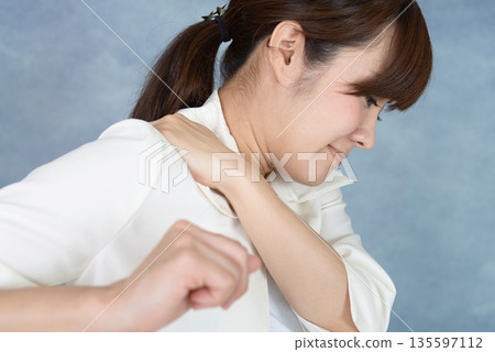 A woman suffering from stiff shoulders 135597112