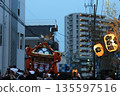 A summer festival scene at night illuminated by portable shrines and lanterns 135597516