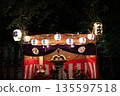 A summer festival scene at night illuminated by portable shrines and lanterns 135597518