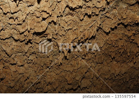 Lava stalactites in the ceiling of a cave. Lava stalactites in the ceiling of a cave. 135597554