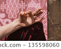 Hand Performing Yoga Gesture Against Patterned Mat 135598060