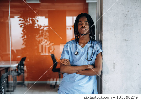 Arms crossed, standing. Black man doctor is in the office 135598279
