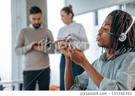 Cute little plane, in airline company. People are working in the office together Cute little plane, in airline company. People are working in the office together 135598392