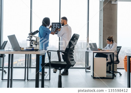 X-ray in hands, researching. Doctors are in the clinic X-ray in hands, researching. Doctors are in the clinic 135598412