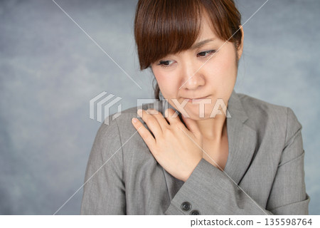 A woman suffering from stiff shoulders A woman suffering from stiff shoulders 135598764