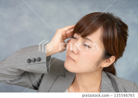 A woman suffering from a headache 135598765