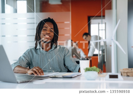Cup of fresh coffee. People are working in the office together Cup of fresh coffee. People are working in the office together 135598938