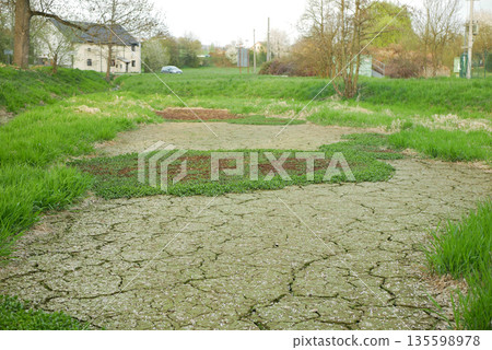 Drought cracked pond in village mud lake drying up and without water. Desiccation dried up soil mud crust and wild fire risk. Dry degradation due to climate change, ocean temperatures, changes in the Drought cracked pond in village mud lake drying up and without water. Desiccation dried up soil mud crust and wild fire risk. Dry degradation due to climate change, ocean temperatures, changes in the 135598978