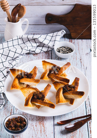 Baked creative toasts with berry jam on a plate on the table vertical view 135599013