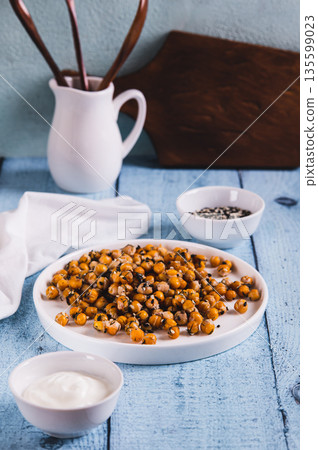 Delicious baked chickpeas with dill and sesame seeds on a plate on the table vertical view Delicious baked chickpeas with dill and sesame seeds on a plate on the table vertical view 135599023