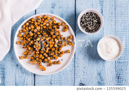 Delicious baked chickpeas with dill and sesame seeds on a plate on the table top view Delicious baked chickpeas with dill and sesame seeds on a plate on the table top view 135599025