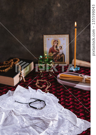 An Orthodox cross, candles, a lamp, and an icon for home prayer on the table vertical view 135599043