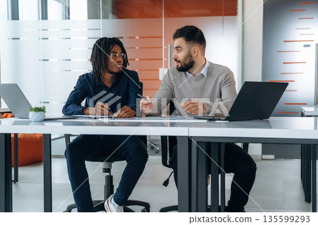 Some paperwork. Two men are in the office Some paperwork. Two men are in the office 135599293