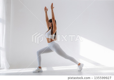 Warrior yoga asana. Young sportive woman is in the studio Warrior yoga asana. Young sportive woman is in the studio 135599927