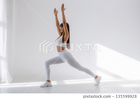 Warrior yoga asana. Young sportive woman is in the studio 135599928