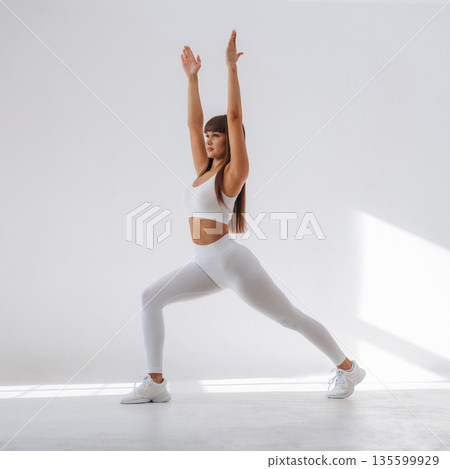Warrior yoga asana. Young sportive woman is in the studio Warrior yoga asana. Young sportive woman is in the studio 135599929