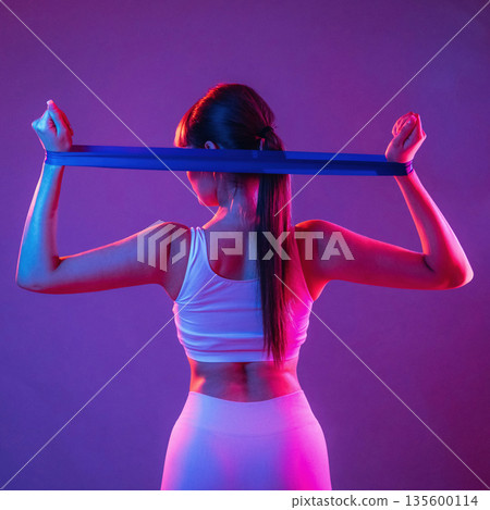 Stretching hands. Young sportive woman is in the studio 135600114