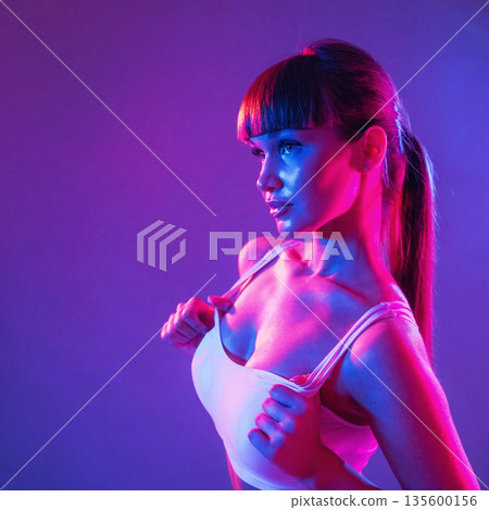 Touching the top, neon lighting. Young sportive woman is in the studio Touching the top, neon lighting. Young sportive woman is in the studio 135600156