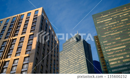 Modern city skyscrapers against clear blue sky, contemporary urban architecture, business district buildings 135600232