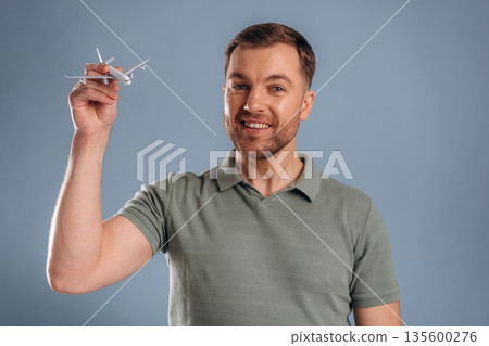 Airline concept, travel, ready for vacation. Handsome man is against background Airline concept, travel, ready for vacation. Handsome man is against background 135600276