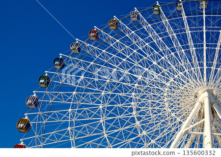 Ferris wheel structure against blue sky, amusement park attraction Ferris wheel structure against blue sky, amusement park attraction 135600332