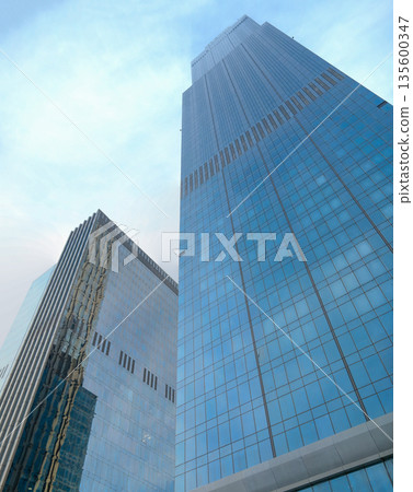 Tall glass office buildings viewed from ground level perspective Tall glass office buildings viewed from ground level perspective 135600347