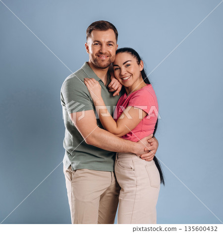 Embracing, standing and posing. Man and woman are in the studio 135600432