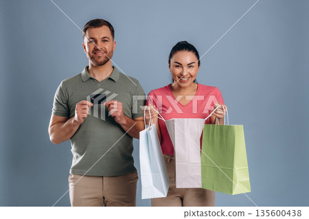 Ready to make purchase, credit card and shopping bags. Man and woman are in the studio 135600438