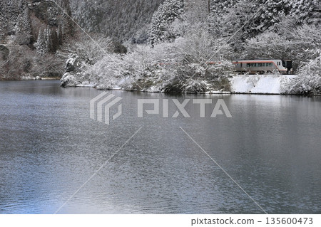 The Hida Express runs along the Hida River in winter scenery 135600473