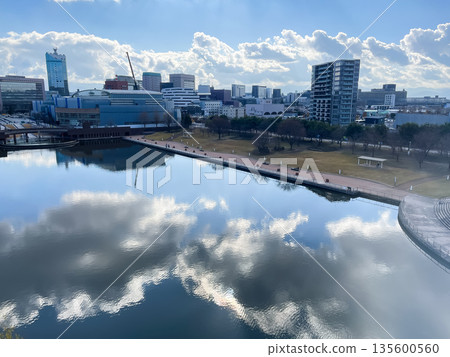 The cityscape of Toyama City, Toyama Prefecture, seen from Fugan Canal Kansui Park. The sky reflects off the water, creating a beautiful winter scene. 135600560