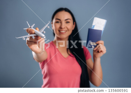 Travel time, vacation, with tickets. Beautiful woman is against background 135600591