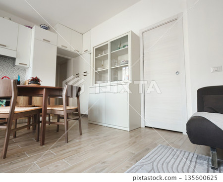 Living room design with white buffet and pencil case door. Scandinavian-style interior. Minimalism and modern renovation.  135600625