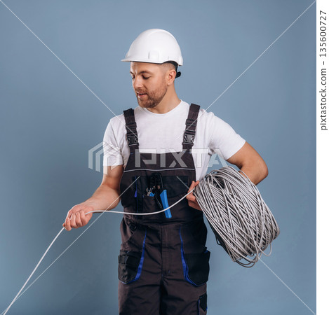 Providing the internet connection, guy in hardhat. Handsome man is against background 135600727