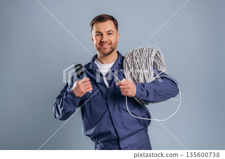 Worker is ready to install the internet connection. Handsome man is against background Worker is ready to install the internet connection. Handsome man is against background 135600738
