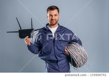 Worker is ready to install the internet connection. Handsome man is against background Worker is ready to install the internet connection. Handsome man is against background 135600742