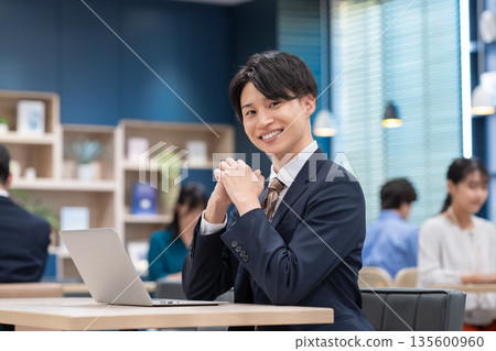 工作在辦公室的一個年輕商人 135600960