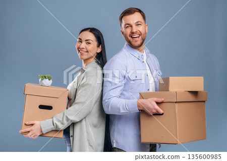 Couple is ready to move, with boxes. Man and woman are in the studio Couple is ready to move, with boxes. Man and woman are in the studio 135600985
