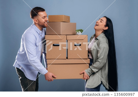 Together with boxes, moving. Man and woman are in the studio 135600997